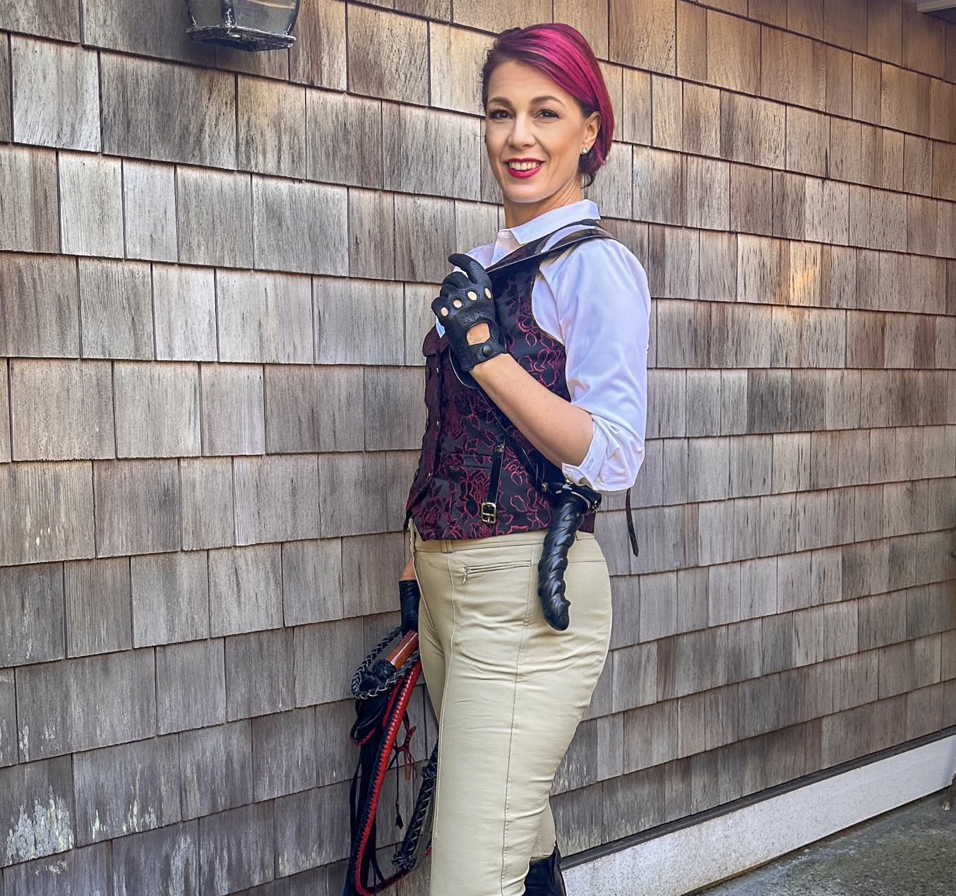 Viktoria Sway smiling in riding gear with crop in hand