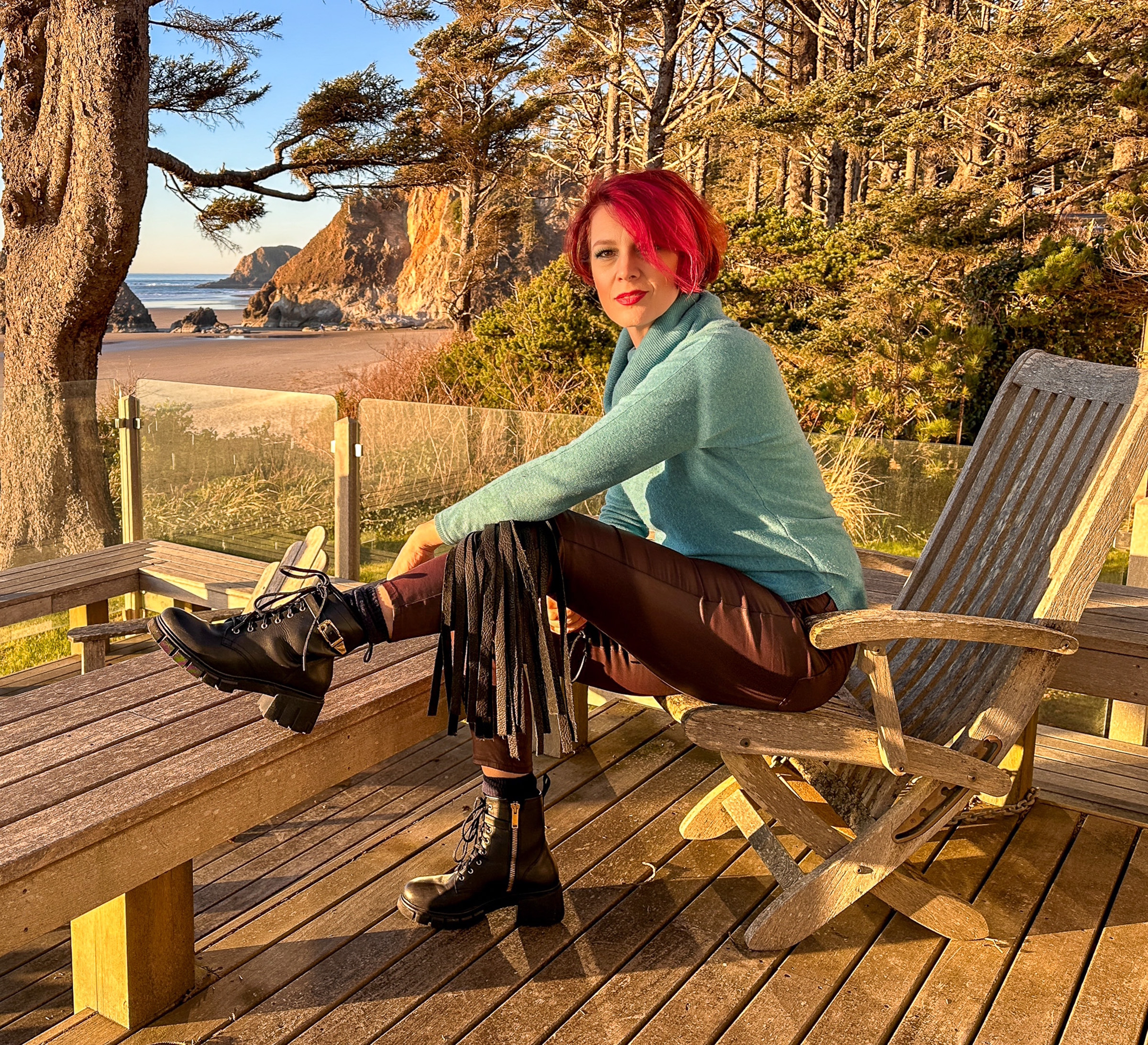 Viktoria Sway seated on a coastal deck at golden hour, Oregon coast behind her